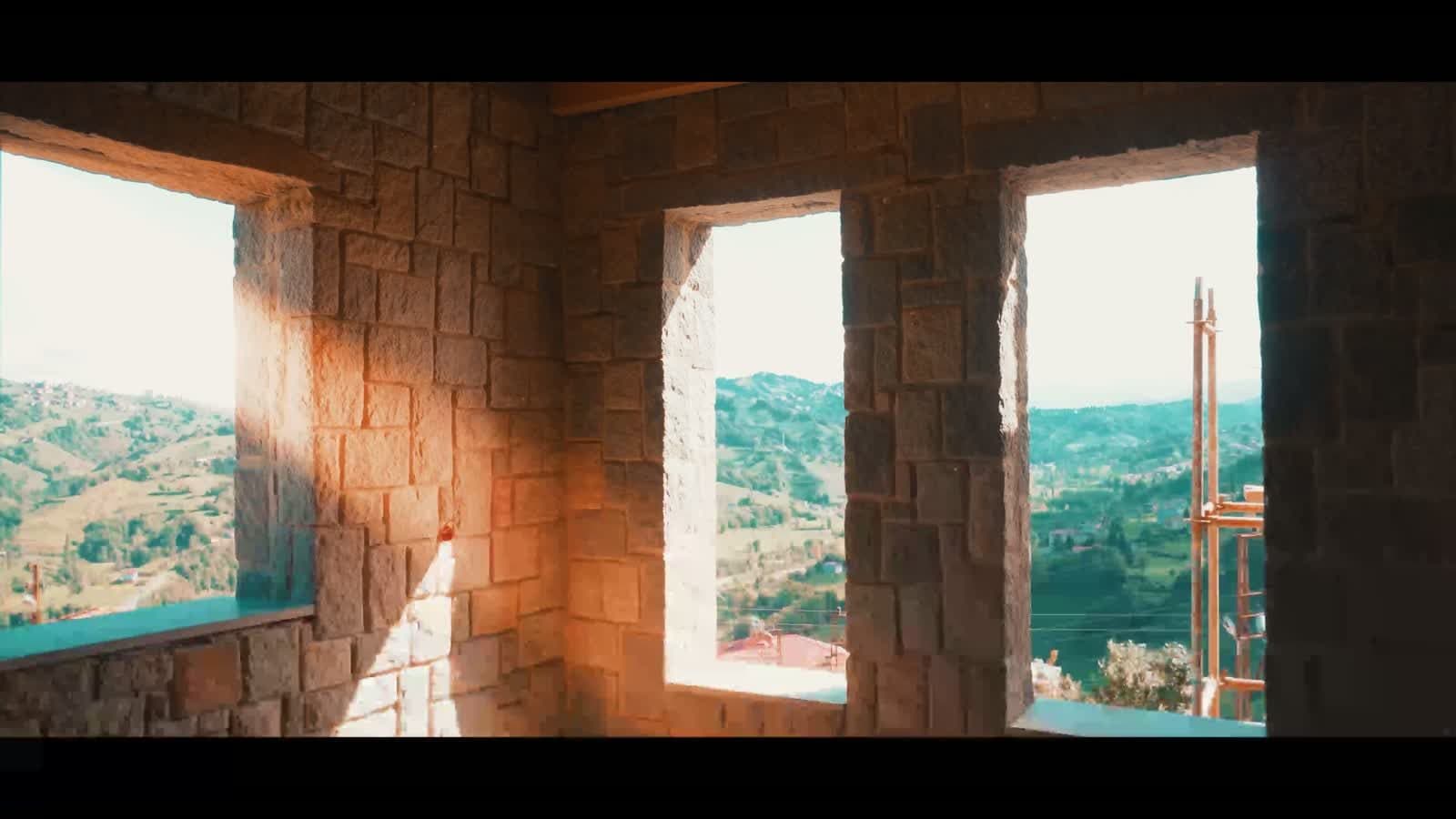 Stone masonry and window openings framing the landscape